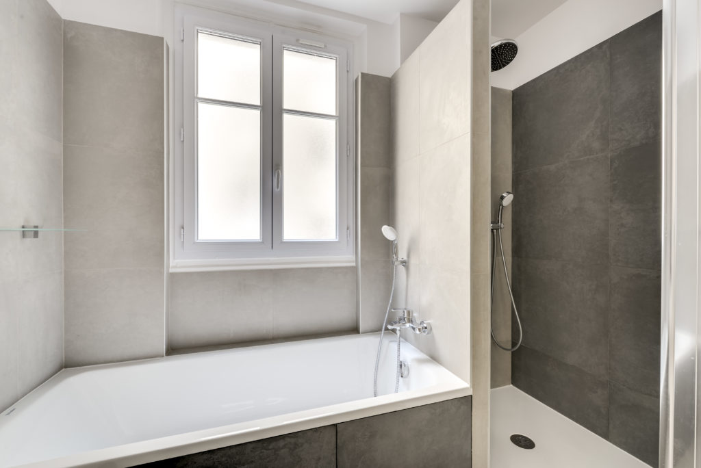 Rénovation d'une salle de bains avec baignoire et douche dans un appartement familial à Paris